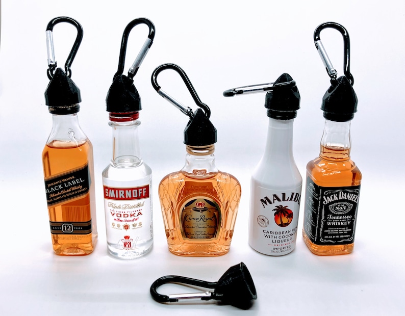 May include: Six miniature liquor bottles with black carabiner clips attached to the tops. The bottles are labeled Jack Daniels, Crown Royal, Malibu, Smirnoff, and Black Label.