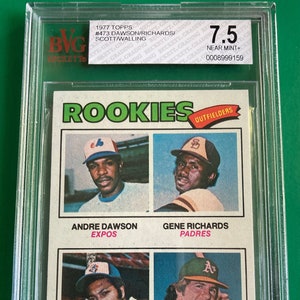 May include: A 1977 Topps baseball card graded 7.5 near mint plus. The card features four rookie outfielders: Andre Dawson, Gene Richards, John Scott, and Denny Walling.