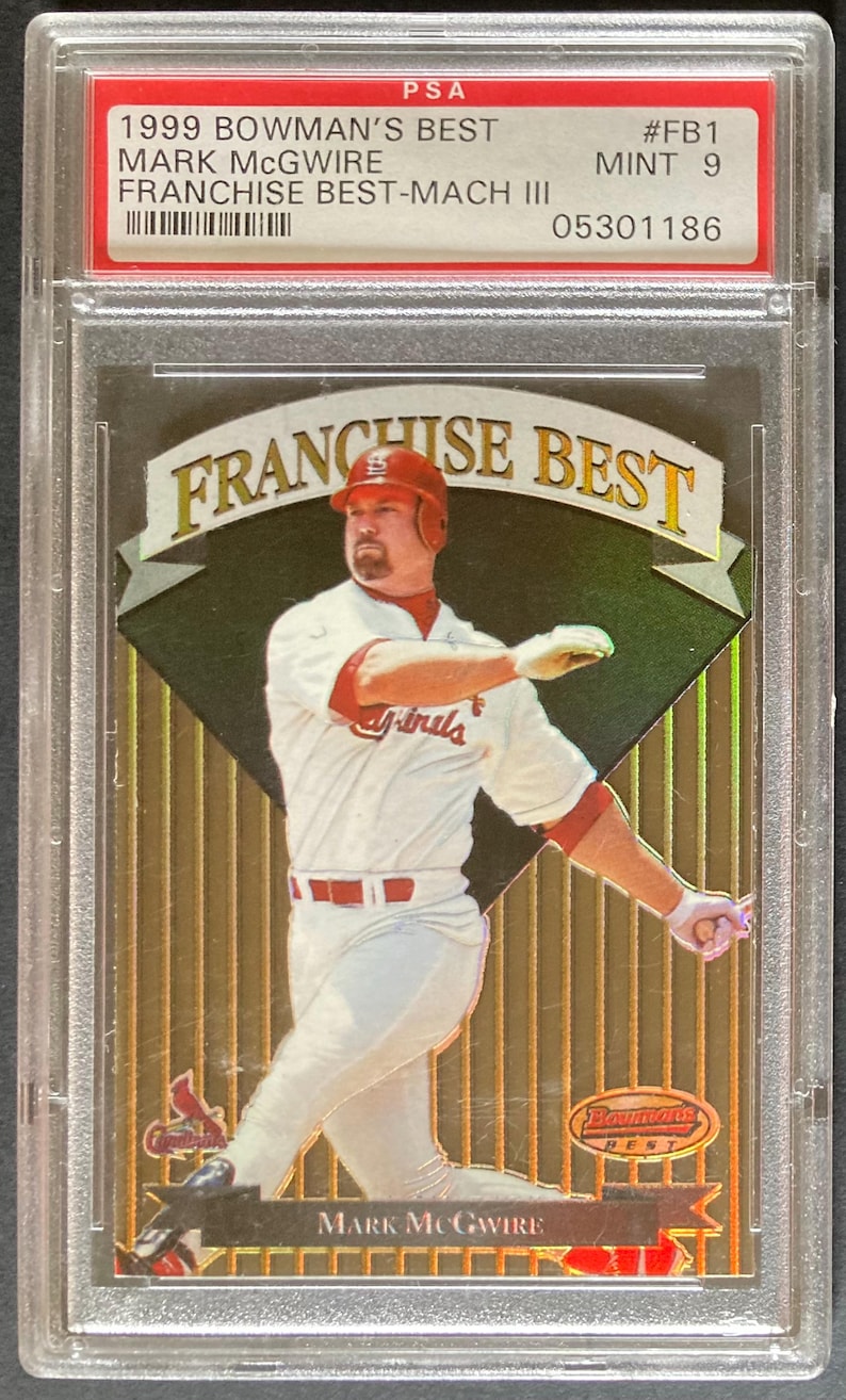 Puede incluir: Una tarjeta de b&eacute;isbol de Mark McGwire de 1999 de Bowman's Best, calificada MINT 9 por PSA, en un soporte protector. La tarjeta presenta a un jugador con uniforme blanco y rojo, con el texto "FRANCHISE BEST".