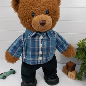 Build a bear teddy bear wearing a blue checked shirt and black trousers.