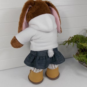 A build a bear teddy bear wearing a white hoodie, blue denim skirt and sand coloured boots