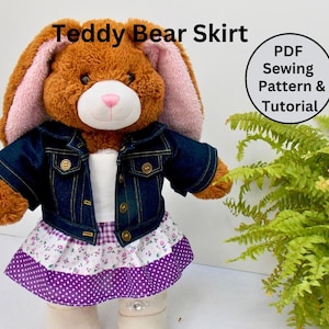 May include: A brown teddy bear wearing a denim jacket and a purple and white skirt. The bear has pink bunny ears. The image includes the text "Teddy Bear Skirt" and "PDF Sewing Pattern & Tutorial".