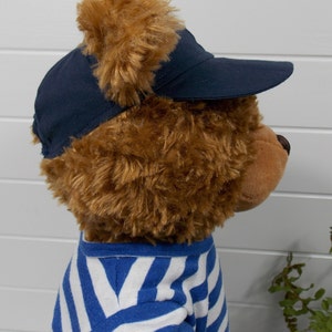 Build a bear teddy bear wearing a blue baseball cap and a blue and white t-shirt