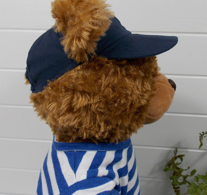 Build a bear teddy bear wearing a blue baseball cap and a blue and white t-shirt