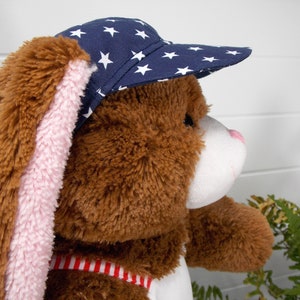 Build a bear teddy bear wearing a blue baseball cap with white stars