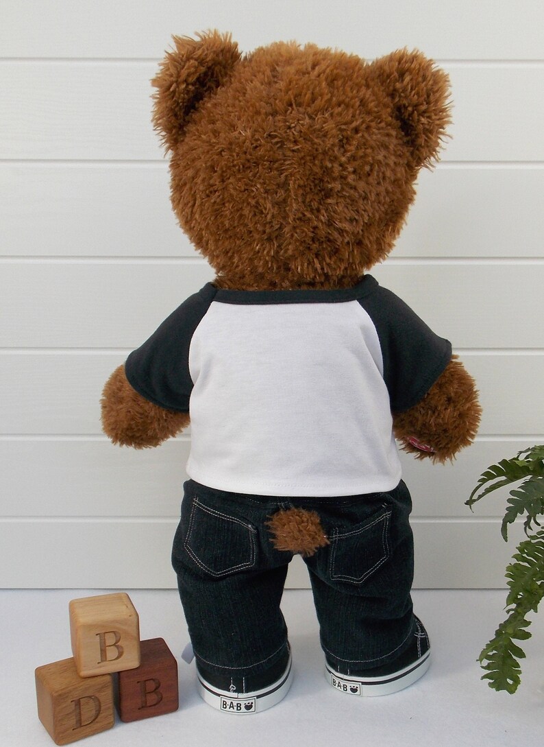 Build a bear teddy bear wearing a black and white t-shirt, black jeans and black and white converse trainers.