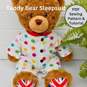 Puede incluir: Un oso de peluche marrón que lleva un pijama blanco con lunares de colores. El pijama tiene un ribete rojo alrededor del cuello y un cierre de botón. El oso de peluche está sentado sobre una superficie blanca con una planta verde en el fondo. El texto "Teddy Bear Sleepsuit PDF Sewing Pattern & Tutorial" es visible en la imagen.