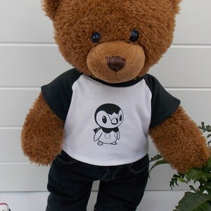 Build a bear teddy bear wearing a black and white t-shirt with a Pokemon figure (Piplup) on the front, black jeans and black and white converse trainers.