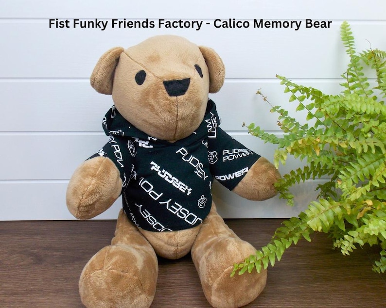 Funky Friends Factory Calico Bear wearing a black patterned hoodie