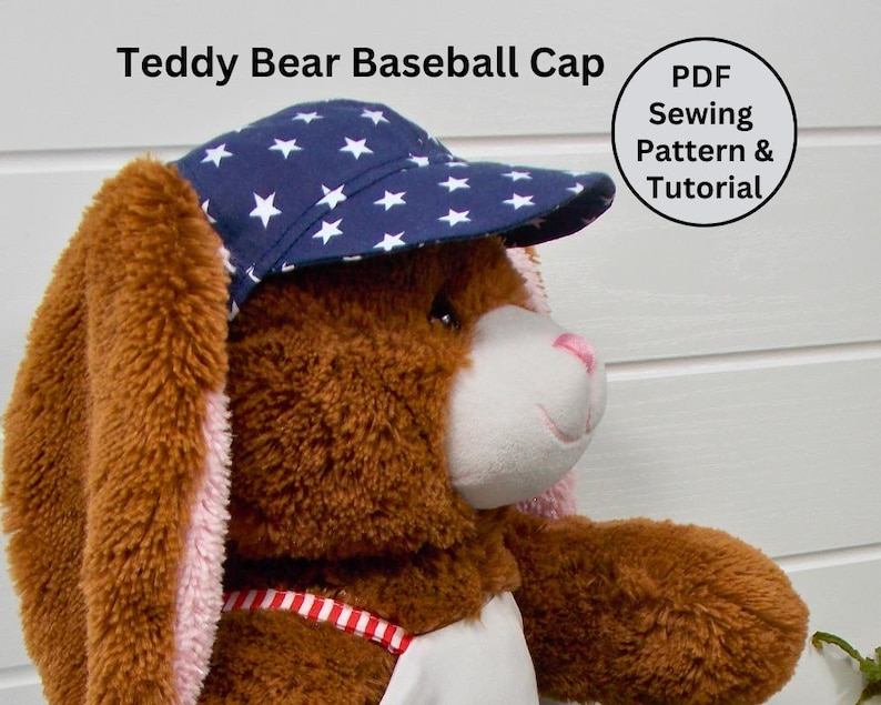 Pu&ograve; includere: Un orsacchiotto marrone che indossa un berretto da baseball blu con stelle bianche. Il berretto ha una visiera curva. Il testo "PDF Sewing Pattern & Tutorial" &egrave; su un cerchio bianco nell'angolo in alto a destra dell'immagine.