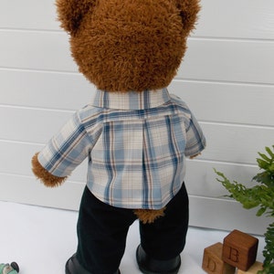 Build a bear teddy bear wearing a checked shirt and black trousers.