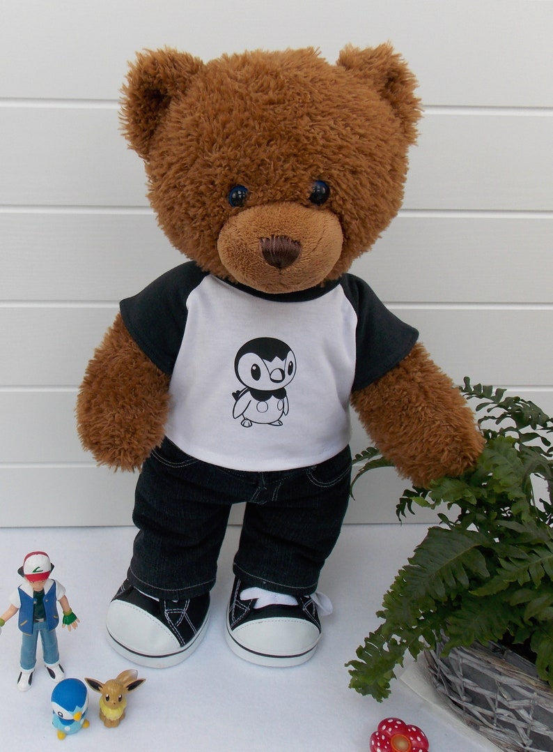 Build a bear teddy bear wearing a black and white t-shirt, black jeans and black and white converse style trainers.