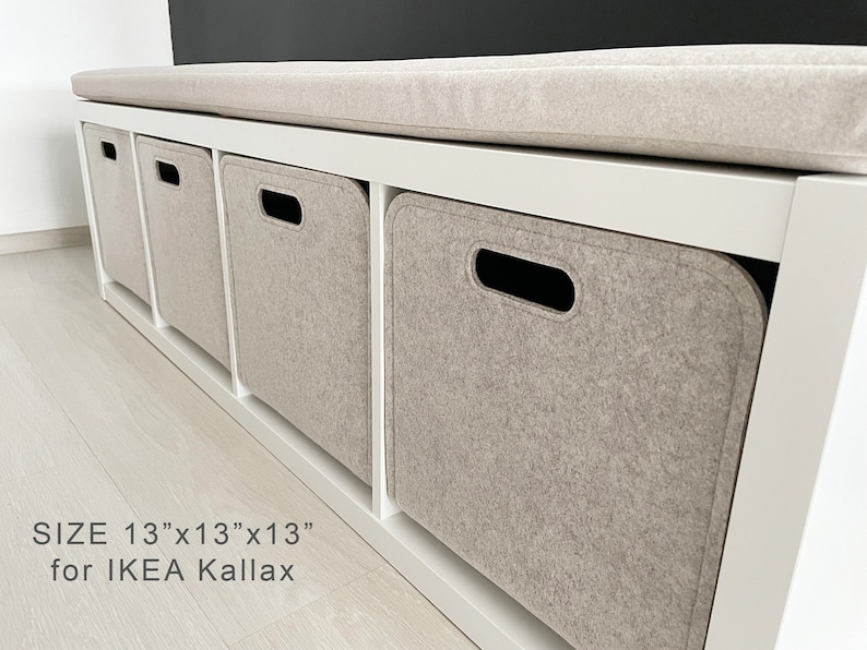 May include: A white storage bench with four cubbies, each containing a light gray felt storage bin. The bench has a light gray cushioned top. The text on the image reads "SIZE 13"x13"x13" for IKEA Kallax."