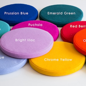 May include: Nine round felt cushions in various colors, including turquoise, bean blue, Prussian blue, fuchsia, bright lilac, emerald green, red berry, chrome yellow, and orange red.