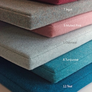 May include: A stack of six fabric swatches in various colors, including teal, turquoise, oatmeal, muted pink, agate, and cinnamon pink. Each swatch has a number and color name printed on it.
