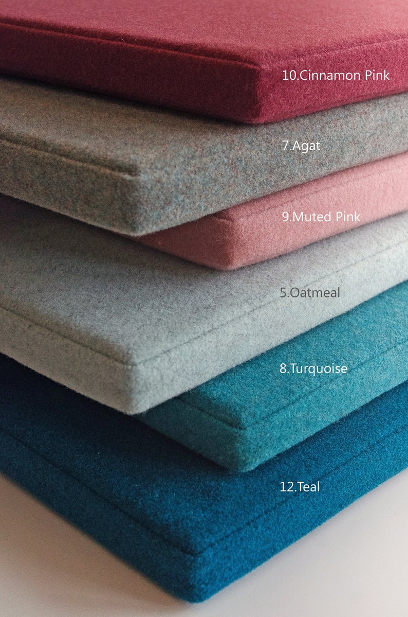 May include: A stack of six fabric swatches in various colors, including teal, turquoise, oatmeal, muted pink, agate, and cinnamon pink. Each swatch has a number and color name printed on it.