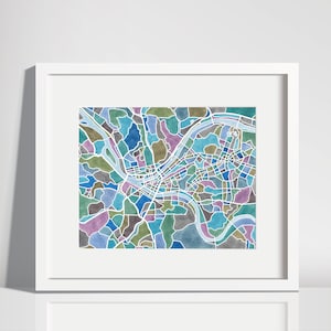 May include: A watercolor map of a city with a river winding through it. The map is in shades of blue, green, and purple.