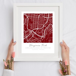 May include: A white framed print with a red background map of the Virginia Tech Carilion School of Medicine in Roanoke, Virginia.
