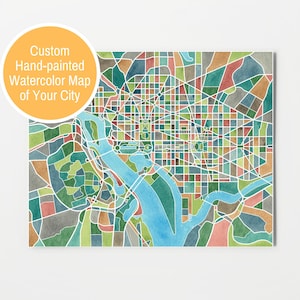 May include: A watercolor map of Washington, D.C. with a blue river winding through the city. The map is divided into colorful blocks, each representing a different neighborhood. The map is framed and ready to hang.