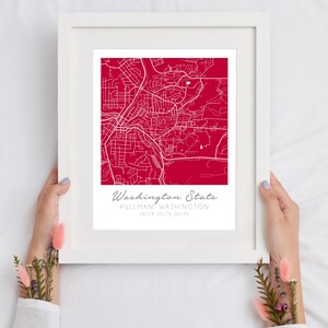 May include: A white framed print with a red background and a white outline of a map of Pullman, Washington. The text "Washington State" is written in white cursive at the bottom of the print, along with the text "Pullman, Washington" and "Delta Delta Delta" in smaller white text.