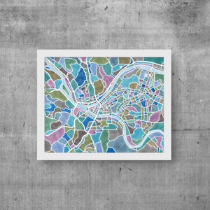 May include: A watercolor illustration of a city map with a river winding through it. The map is filled with different shades of blue, green, and purple.