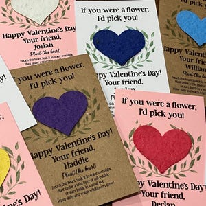 May include: Valentine's Day cards with heart-shaped seed paper. Each card has a heart in a different color, with text that reads "If you were a flower, I'd pick you!" and "Happy Valentine's Day!"