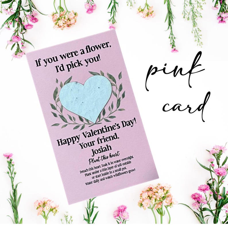 May include: A pink Valentine's Day card with the text "If you were a flower, I'd pick you!" and "Happy Valentine's Day!" A light blue heart is in the center, surrounded by green leaves. The card includes instructions to plant the heart.