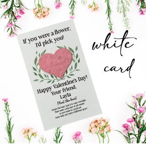 May include: A white card with the text "If you were a flower, I'd pick you!" and "Happy Valentine's Day! Your friend, Layla." A pink heart is in the center, surrounded by green leaves. The words "Plant this heart" are also on the card.