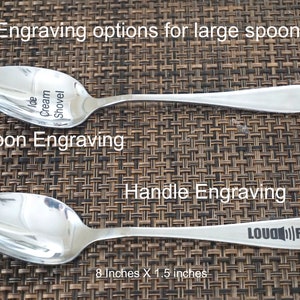 May include: Two stainless steel spoons with different engraving options. The top spoon is engraved with "Ice Cream Shovel" on the bowl. The bottom spoon is engraved with "LOUD RUMOR" on the handle. The spoons are 8 inches long and 1.5 inches wide.