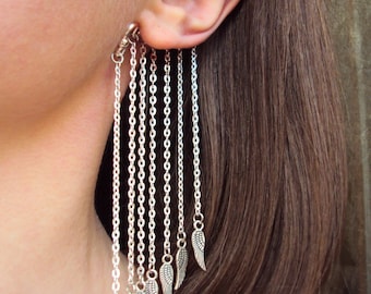 May include: Silver ear cuff with multiple dangling chains and small wing charms.