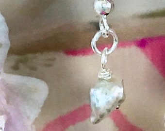 Unassuming pair of Pierced earrings with milky white Keshi freshwater pearls dangling from sterling silver ear wires.