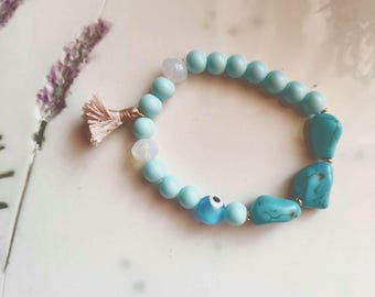 Turquoise beaded bracelet with evil eye bead and tassel.