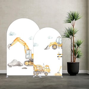 May include: Two white arched backdrop stands with watercolor illustrations of construction vehicles, including an excavator, a front-end loader, and a cement mixer. The backdrop also features gray clouds and a pile of rocks.