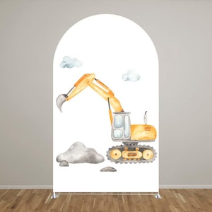 May include: A white arch-shaped backdrop featuring a watercolor illustration of a yellow excavator with a raised arm, gray rocks, and two fluffy blue clouds. The excavator has a gray bucket and black tracks. The backdrop is set against a light gray wall and a wooden floor.