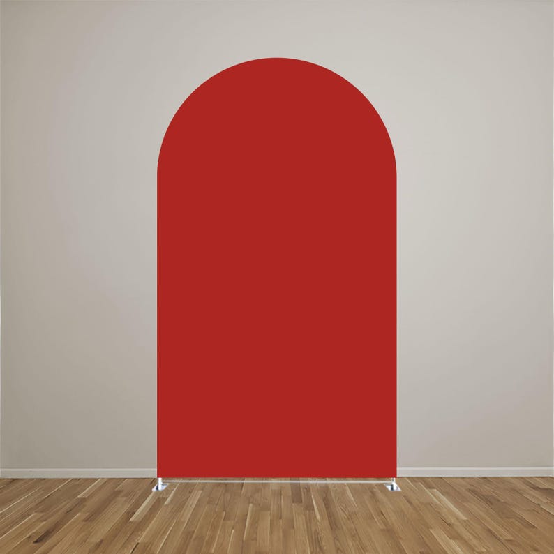 May include: A solid red arch-shaped backdrop cover featuring a smooth, matte fabric surface. The structure has a rounded top and straight vertical sides, supported by a thin metal frame base visible at the bottom, creating a clean, uniform display.