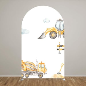 May include: A white arch-shaped backdrop featuring watercolor illustrations of construction vehicles. A yellow front-end loader and a cement mixer truck are depicted, along with a shovel, sand, and construction barriers. The backdrop is suitable for a construction-themed party.