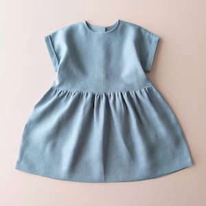 May include: A light blue linen dress with short sleeves and a gathered skirt.