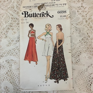 May include: Vintage Butterick sewing pattern envelope. The envelope features illustrations of three different dresses. The text on the envelope reads "Butterick THE FASHION ONE" and includes the size, bust measurement, and pattern number.