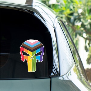 May include: A rainbow pride flag design in the shape of a skull sticker on a car window.