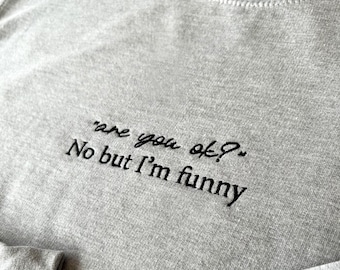 May include: Gray sweatshirt with black embroidered text that reads "are you ok? No but I'm funny."