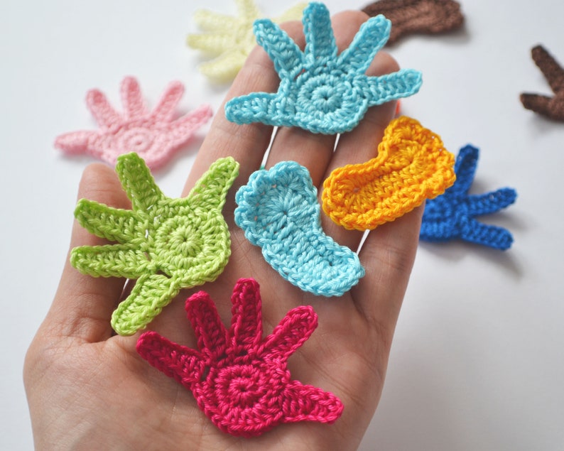 Puede incluir: Una colecci&oacute;n de formas de manos y pies de ganchillo de varios colores, incluyendo azul, verde, rosa, amarillo y rojo.