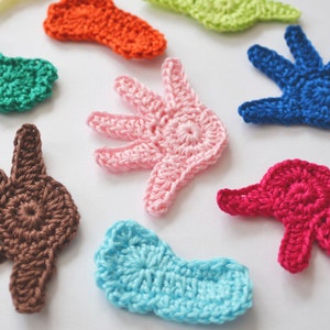 Puede incluir: Surtido de formas de manos de ganchillo de colores en varios colores, incluyendo azul, verde, rosa, marr&oacute;n, rojo, naranja y azul claro.