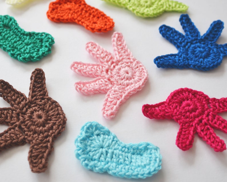 Puede incluir: Surtido de formas de manos de ganchillo de colores en varios colores, incluyendo azul, verde, rosa, marr&oacute;n, rojo, naranja y azul claro.