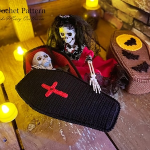 Op de afbeelding: Haakpatroon voor een Halloween-kist met een rood kruis en een skelet erin. De kist is zwart met een rode voering. Het skelet draagt een rode jurk. Het patroon is van Make It Easy Crafts.