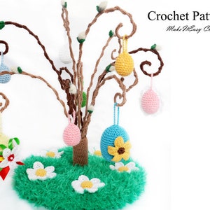 Puede incluir: Patrón de crochet para un árbol de huevos de Pascua. El árbol está hecho de hilo marrón y tiene seis huevos coloridos colgando de él. Los huevos están decorados con flores y otros diseños. El árbol está sentado sobre una base de hierba verde.