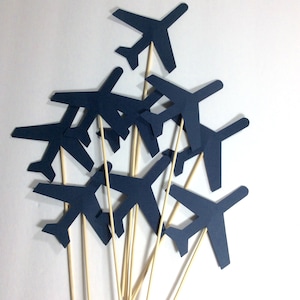 May include: A bundle of navy blue paper airplane party decorations with wooden sticks.