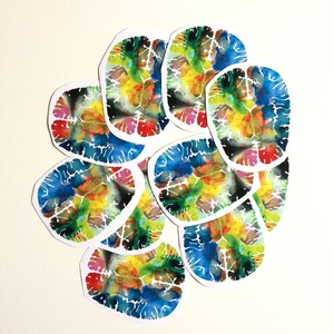 May include: A set of nine watercolour paintings of the human brain, each with a unique and colourful design. The paintings are arranged in a circle, with the edges of each painting overlapping.