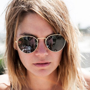 round gold classic sunglasses on model