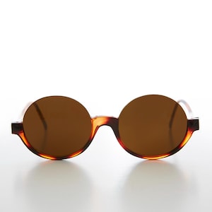 Könnte beinhalten: Runde Sonnenbrille in Schildpatt-Optik mit braunen Gläsern.