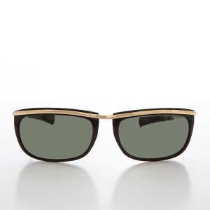 May include: Black sunglasses with a gold metal trim around the lenses. The sunglasses have a retro style.